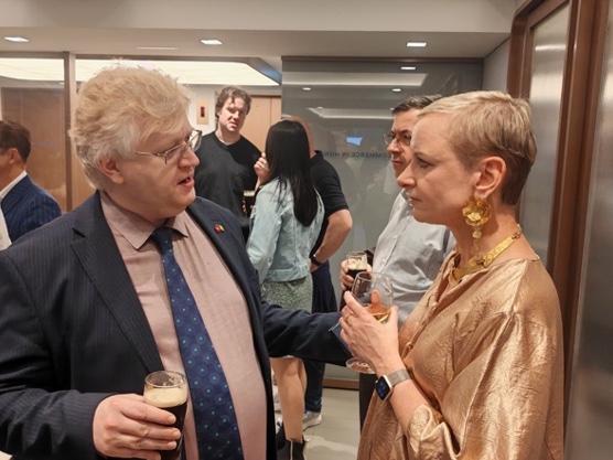 Two guests in conversation with drinks at an evening reception