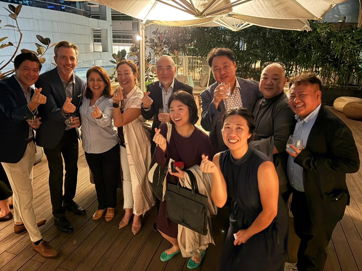 A group raising glasses under a terrace umbrella at night