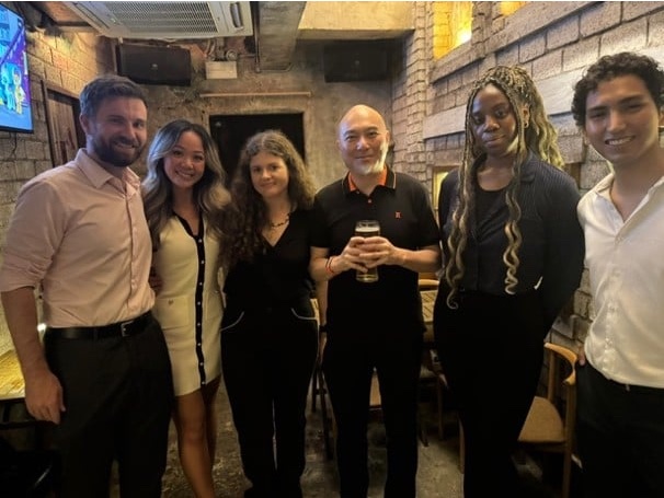 Young professionals standing together in a bar with exposed brick